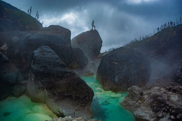 Hot springs in colombian andean paramo Murillo, Tolima, Colombia. Colorful blue water with steam and green frailejon plants in the background