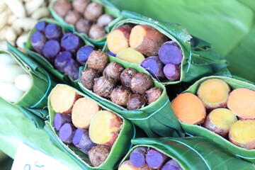 Group of waternut, chinese water chestnut, purple and yeloow sweet potato in banana leaf plate in the fresh market.