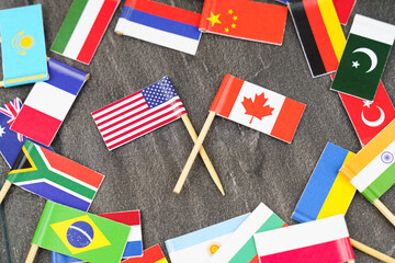 Fototapeta na wymiar The concept is diplomacy. In the middle among the various flags are two flags - USA, Canada