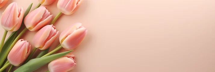 Fotobehang Pink tulip flowers on pastel peach background. Image for a wedding, women's day or mother's day themed greeting card or invitation. Banner with space for text © NeuroCake