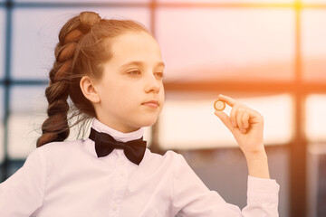 Portrait of cute caucasian teen girl holding coin. Saving money concept.