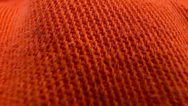 Close-up of orange texture fabric cloth, textile background. Movement from left to right.