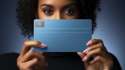 Naklejka premium A young girl holds a blue bank card in her hands, isolated on a blue background. Space for copy, message for presentation. Promotional platform, layout of advertising content.