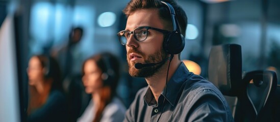 Fototapeta premium Confident call center operator assisting customers in office surrounded by colleagues.