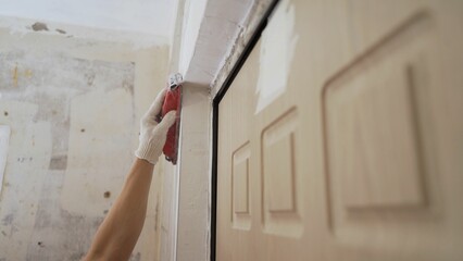 Concrete wall background, hand plastering with plastic sponge to finish cement wall. A worker...