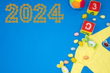 Obraz na płótnie Canvas Baby onesie romper bodysuit product mockup with Baby Pacifier, Teddy bears, socks and various toys and 2024 Happy New Year made from golden chain links