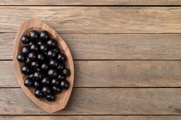 Jabuticabas on a bowl over wooden table with copy space