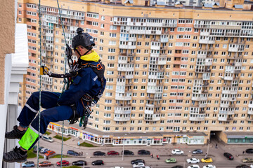 Industry mountaineering laborer climbing on wall residential building during high-rise work. Rope...