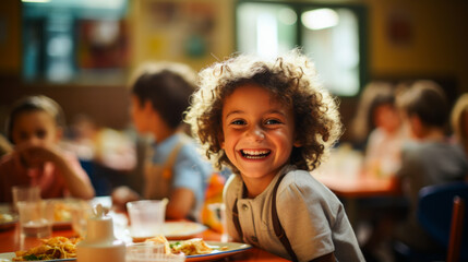 A joyful scene of a 10-year-old child sharing laughter with friends in a cafeteria. - obrazy, fototapety, plakaty