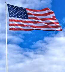 American Flag against a blue sky and white clouds