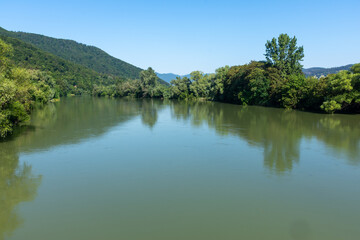 Fototapeta na wymiar River with muddy green water, against the background of trees and hills