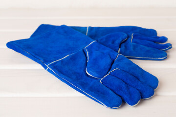 Blue construction gloves on wooden table