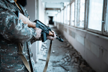 Warrior Amidst Ruins: Soldier with Military Rifle in Dilapidated Building