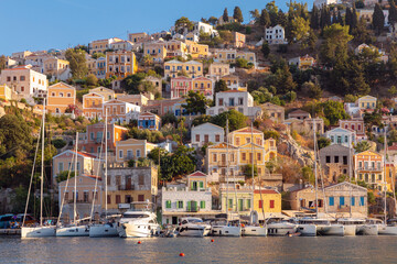 Naklejka premium Multi-colored facades of houses in the village of Symi at sunset.