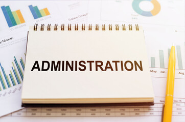 Business concept - words on paper notepad writing ADMINISTRATION on financial background.