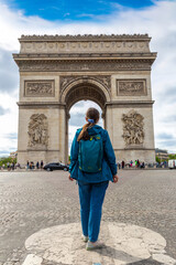 Woman traveler at Paris Arc de Triomphe (Triumphal Arch) in Paris, France
