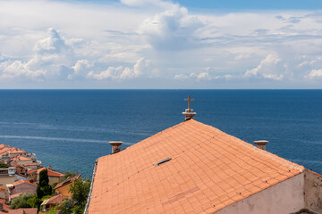 Cross on rooftop of Saint George Church with panoramic aerial view of coastal town Piran,...