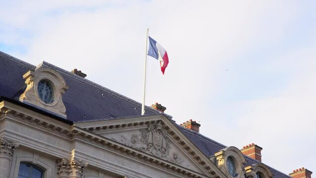 Drapeau fran&ccedil;ais tricolore flottant au vent sur un monument de Paris