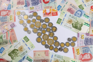 new bank notes of mexican peso and shape of Mexico made with coins background. 20, 50, 100, 200, 500 pesos