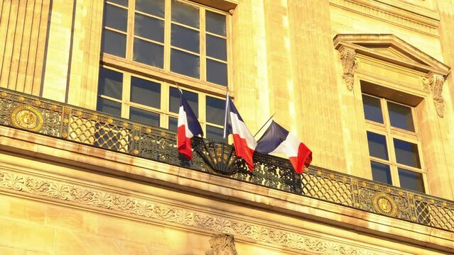 Drapeau fran&ccedil;ais tricolore flottant au vent sur un monument de Paris