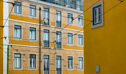 Traditional tiled house with yellow tiles, facade with windows, Lisbon, Portugal