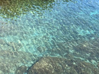 Crystal clear water transparent surface with algae at the bottom