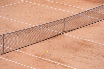 Isolated tennis ball on the clay surface of the tennis court
