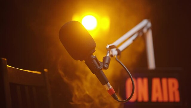 Podcast microphone with spotlight shine on black background 4K