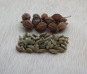 Seeds varieties of cardamom -  Black cardamon seeds, indian cardamom, Green cardamon (Elettaria cardamomum), greater cardamom,  0n wooden background