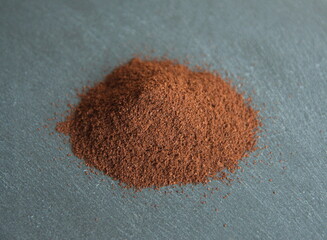 Coffee powder, roasted beans of Coffea arabica, on grey stone background