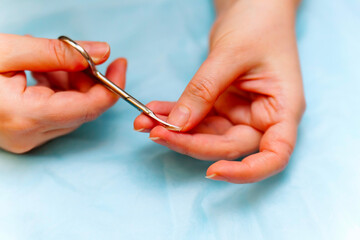 A girl cuts her fingernails with special scissors