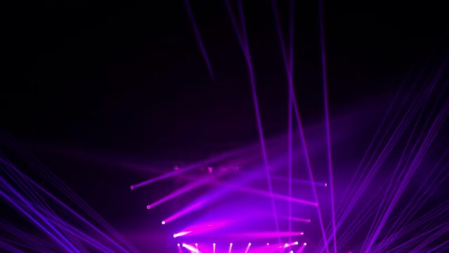 a colorful light show and a huge number of multicolored laser beams in a large indoor space