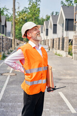 Joyous construction supervisor performing inspection of residential complex