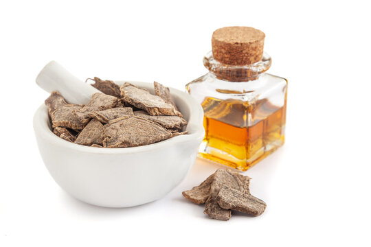 Dry organic kapoor kachri (Hedychium spicatum), in white ceramic mortar and pestle, along with its essential oil.