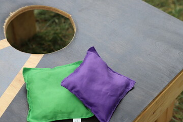 Cornhole or corn hole green and purple bags.