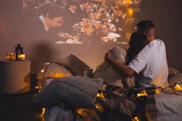 Fotobehang Romantic surprise for girlfriend or boyfriend. Bedroom prepared for watching old movies with popcorn, decorated with lights and candles. Cozy home Christmas atmosphere, hot chocolate with marshmallow © ArtSys