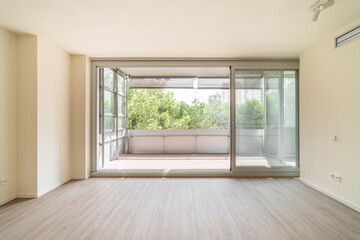 Spacious unfurnished living room with access to large balcony - obrazy, fototapety, plakaty