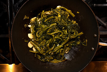 broccoli rabe cooking in a frying pan 