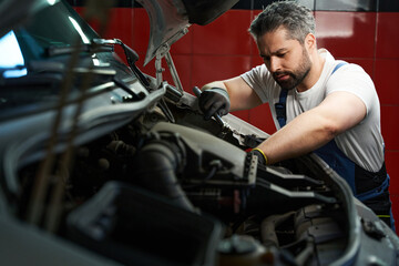Experienced auto mechanic repairing his client car