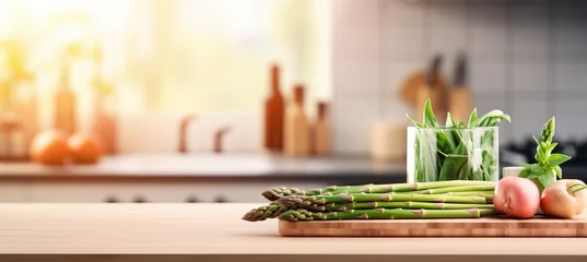 Poster Fresh organic asparagus on wooden table, kitchen background, blurred for text placement © Ilja