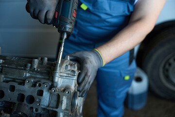 Car mechanic repairing automobile engine in garage