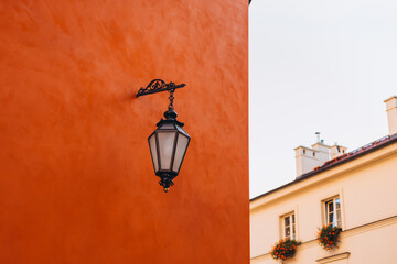 Old antique metal lamp at the beautiful red wall. Victorian vintage street lantern at the day time,...