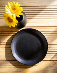 Obraz na płótnie Canvas Black ceramic plate mockup, blanck clean dish on wooden table, mock up