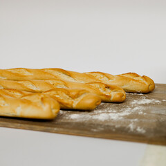Barras de pan baguette sobre una mesa de madera con harina por encima 