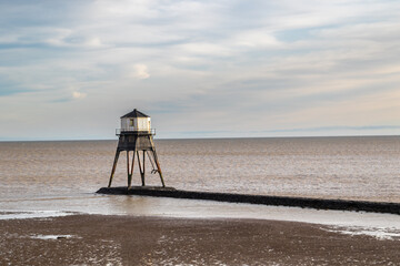 Fototapeta na wymiar Lighthouse in the sea, Dovercourt low lighthouse at low tide built in 1863 and discontinued in 1917 and restored in 1980 the 8 meter lighthouse is still a iconic sight,