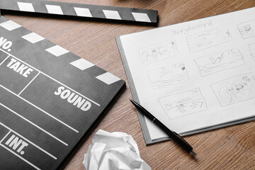 Storyboard with movie clapper on wooden background, closeup