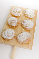 Caracolas en una tabla de madera sobre fondo blanco. Fotografía de producto de panadería pastelería
