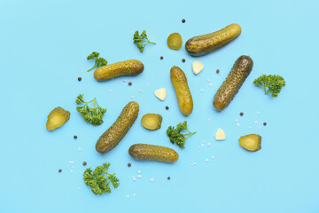 Pickled cucumbers and different spices on blue background - obrazy, fototapety, plakaty