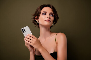Photo of gorgeous lady hold smart phone device look on green empty space background