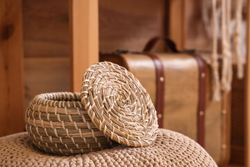 Wicker basket on pouf in room, closeup